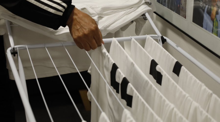 Hector Valeria plockar de nytvättade matchtröjorna från tvättstället.